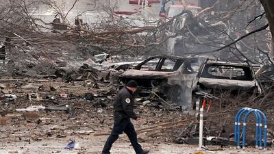 A law enforcement member walks past damage from an explosion in downtown Nashville. AP Photo