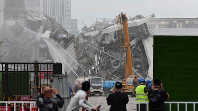 People gather to watch the demolition of the Workers' Stadium. AFP
