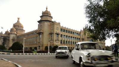 Government owned Ambassador cars of bureaucrats exit the state legislative assembly building, the ‘Vidhana Soudha’ in Bangalore.