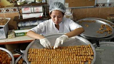 :Mericres Israel, an employee at Firas Sweets in Dubai, arranges a batch of fresh baklava before it goes on sale.