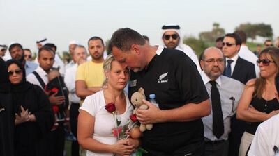Martin and Jane Weeks, the parents of the triplets killed in the Villagio mall fire in Doha, Qatar, attend a memorial with their childrens' stuffed animals in their hands. Lee Hoagland / The National