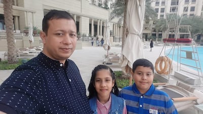 Twins Komal and Khuzaimah pictured with their father, Shefi Ulleh Niazi. Courtesy family