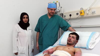 Khayal Mohammed, 20, is recovering thanks to a new technique using placenta tissue to aid healing and reduce scarring. He is pictured with Dr Marwan Al Zarouni at Rashid Hospital. DHA