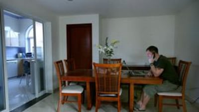 Stuart Foster uses an online chat programme to speak with his wife and sons who are on holiday in England.