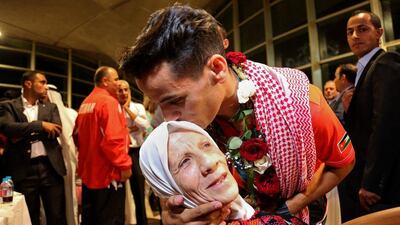 Ahmed Abughaush kisses his mother. Raad Adayleh / AP Photo