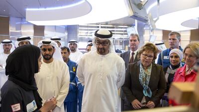 Sheikh Mohammed bin Zayed, centre, Crown Prince of Abu Dhabi and Deputy Supreme Commander of the UAE Armed Forces, speaks with Meerah Al Mulla, production engineer, left, at the Al Hosn gas facility. Ryan Carter / Crown Prince Court - Abu Dhabi