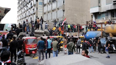 Iraqi protesters carry the Iraqi national flag as they gather on concret blocks which were used by security forces to close the Al-Khilani square in central Baghdad, Iraq. EPA
