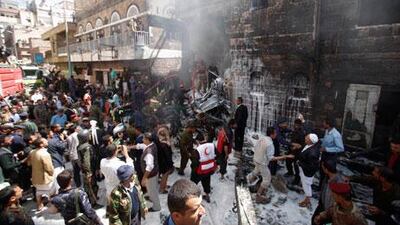Military personnel and fire fighters try to extinguish a fire where a military plane crashed in Sanaa on Tuesday. Khaled Abdullah / Reuters