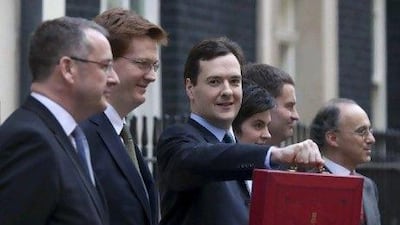 George Osborne, the UK Chancellor of the Exchequer, centre, presents Britain's budget proposals outside 11 Downing Street, yesterday.