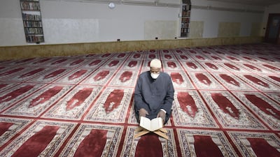 The Imam of the of the Islamic Centre of Bergamo, Boureima Songne, wearing a protective mask, reads Quran amid the coronavirus outbreak on the first day of the holy month in the mosque of Bergamo, Italy, 24 April 2020. EPA