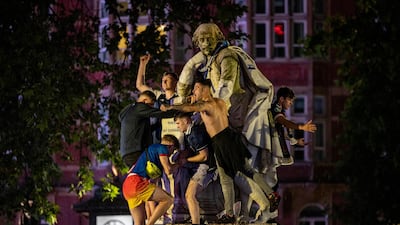 Scotland fans climb a statue of William Shakespeare in Leicester Square. Getty