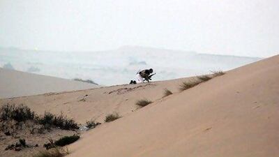 A member of the Egyptian security forces takes position on a sand dune during an operation in the northern Sinai peninsula yesterday. The operation killed 20 militants in the Sinai village of Tumah in retaliation for a weekend ambush that cost the lives of 16 Egyptian soldiers.