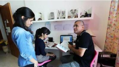 Hussam Dalile with his daughters Line and Boushra at his home in the Sky Court Tower, Dubai ( Pawan Singh / The National )