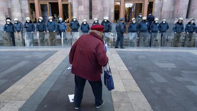 A demonstrator stands in front of Armenian police officers, who guard the house of parliament following protests, which erupted after the signing of a deal to end the military conflict over the Nagorno-Karabakh region, in Yerevan, Armenia. Reuters