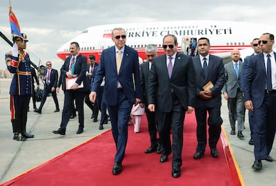 Egyptian President Abdel Fattah El Sisi, centre right, welcomes Turkish President Recep Tayyip Erdogan, centre left, upon his arrival at Cairo Airport on Wednesday. EPA