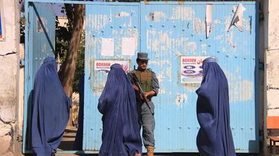 An Afghan policeman stands guard as women arrive to cast their ballot at a polling station during the presidential elections run-off, in Jalalabad, Afghanistan. Ghulamullah Habibi / EPA
