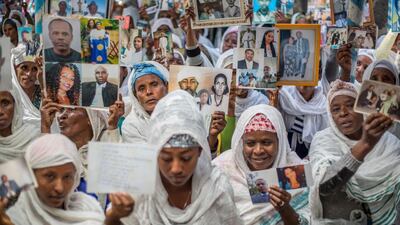 Members of Ethiopia's Jewish community hold pictures of their relatives in Israel, during a solidarity event at the synagogue in Addis Ababa. Mulugeta Ayene / AP