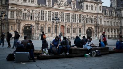 Parisians and homeless gather in front of Paris city hall, one hour after the 19h00 curfew, in Paris. France's prime minister Jean Castex on Thursday defended new nationwide measures to combat a resurgent coronavirus in France that include closing schools for at least three weeks and putting in place a month-long domestic travel ban, the government has acted "consistently and pragmatically". AP Photo