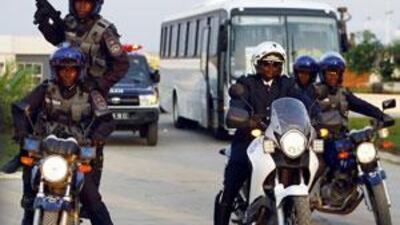 Angolan police special forces guard a bus as it leaves the Olympic Village in Cabinda.