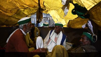 Farmers rest on a tractor trailer near a police road block stopping them from marching to New Delhi to protest against the central government's recent agricultural reforms. AFP
