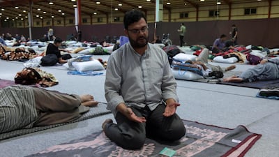 An Iranian pilgrim prays as others rest in Arbil, the capital of Iraq's autonomous Kurdish region, before continuing their journey towards Karbala. AFP