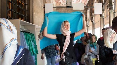 A foreign tourist dons a head covering as she visits the Blue Mosque in Istanbul.