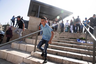 A Palestinian child runs from police at Damascus Gate. AP