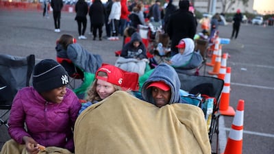 Mark Swindell (R) and his daughters Ivy (L) and Ella try to keep warm at dawn while waiting in line to attend a campaign rally with U.S. President Donald Trump at Phoenix Goodyear Airport n Goodyear, Arizona. AFP