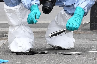 A British police forensics officer holds a knife as evidence is collected on Whitehall near the Houses of Parliament in central London, at the scene where Khalid Mohammed Omar Ali was detained and taken away by police. AFP / Justin Tallis