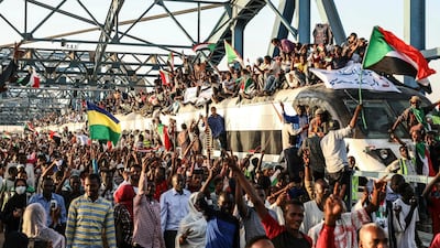 Sudanese protesters crowd a train as it arrives at the main sit-in of the demonstration in the capital Khartoum -- the country needs aid and loans for its economy to ride out political uncertainty. AP