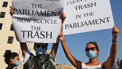 Lebanese protesters hold up placards as they protest against the trash crisis. Hussein Malla / AP Photo
