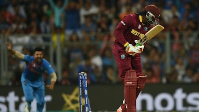 India’s Suresh Raina, left, celebrates as West Indies’s Chris Gayle is bowled out during the World T20 men’s semi-final match between India and West Indies at The Wankhede Cricket Stadium in Mumbai on March 31, 2016. / AFP / INDRANIL MUKHERJEE