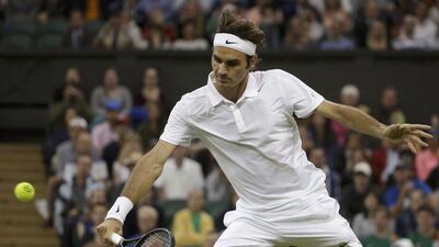 Roger Federer hits a return against Gilles Muller in his second-round win at the 2014 Wimbledon Championships on Thursday. Max Rossi / Reuters / June 26, 2014