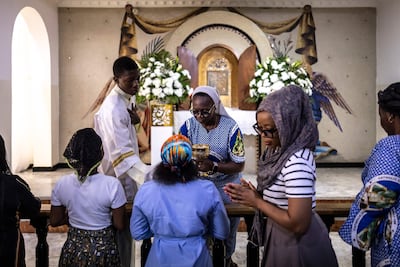 A nun gives communion to Catholics at Mass at the Church of the Assumption in Lagos on April 21. AFP