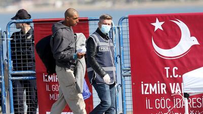 Refugees are escorted by Turkish police as they arrive by ferry from the Greek island of Lesbos at the Dikili harbour in Izmir, Turkey. Some 160 migrants, from Pakistan, Bangladesh and Morroco, who refused to apply for asylum, were deported under an agreement between the EU and Turkey on the refugee crisis. Tolga Bozoglu / EPA