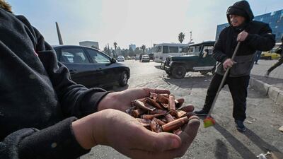 Men sweep the street to clear bullet shells at Umayyad Square in Damascus, after celebratory gunfire marking Syria's liberation from the Assad regime. AFP