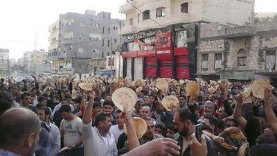 An image taken on a mobile phone showing Syrian men carry bread loaves during a protest against President Bashar Assad's regime, in the coastal town of Banias, Syria.