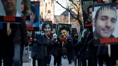 People hold signs with images of the victims of downed Ukraine International Airlines flight PS752. AFP