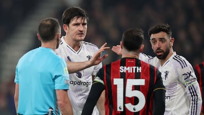 Manchester United's Harry Maguire reacts with Bruno Fernandes after he is shown a red card by referee Stuart Attwell. Reuters