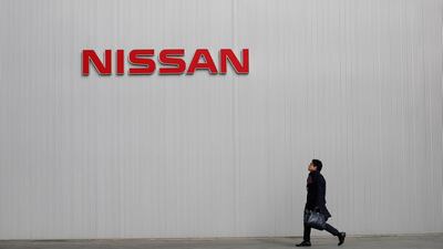 FILE PHOTO: A man walks under the logo of Nissan Motor Co at the company's showroom in Yokohama, south of Tokyo February 8, 2013. REUTERS/Toru Hanai/File Photo