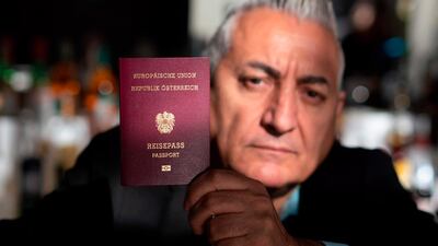 Alper Yilmaz, an Austrian with Turkish roots, poses with his Austrian passport at his cafe in Vienna AFP