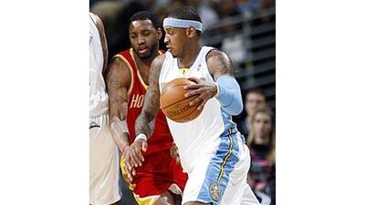 Nuggets forward Carmelo Anthony, front, works the ball inside as Rockets' Tracy McGrady covers in the first quarter.