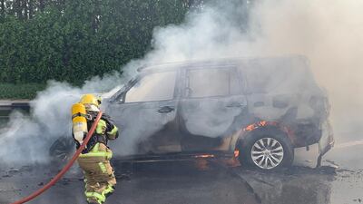 A firefighter extinguishing a car on fire. Road accidents are one of the most common causes of traumatic brain injuries.