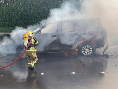 A firefighter extinguishing a car on fire. Road accidents are one of the most common causes of traumatic brain injuries.