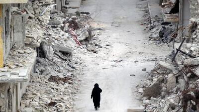 A woman walks past damaged buildings in the rebel-controlled area of Maaret Al Numan town in Syria's Idlib province on May 13, 2016. Khalil Ashawi / Reuters