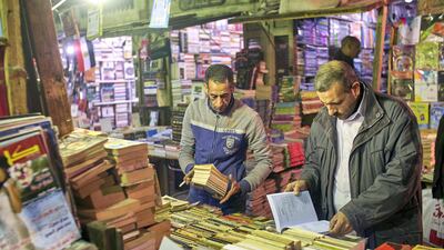 Ahmed Abdel-Fattah, left, and a customer, right, at the second hand book market. Courtesy Hamada Elrasam