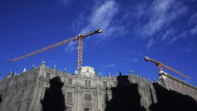 Cranes stand over the old headquarters of the Spanish Credit Bank in Madrid. The emblematic building is undergoing renovation to house a 5-star luxury hotel, an upscale shopping mall and an upscale residential area. Susana Vera / Reuters