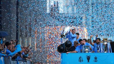 Manchester City players carry the Uefa Champions League trophy, the FA Cup trophy and the Premier League trophy during the Treble Parade in Manchester in June. PA Wire
