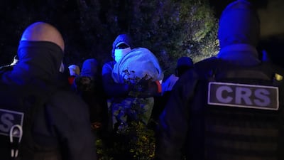 French police stop a group of migrants, including some small children, who were on their way to board a small boat to cross the English Channel. PA