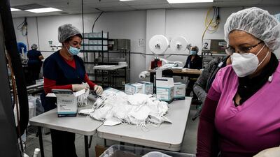 Employees work as they make respiratory masks in a factory in Florida. Women, minorities, the young and the less educated will probably be the hardest hit by the pandemic. AFP